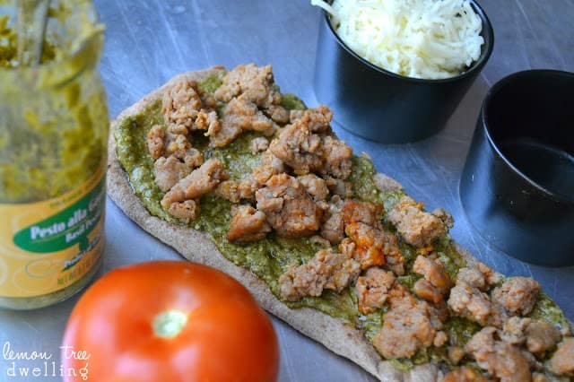 These Pesto Sausage Flatbreads combine traditional basil pesto with sweet Italian sausage to make an easy appetizer that is simply delicious! 