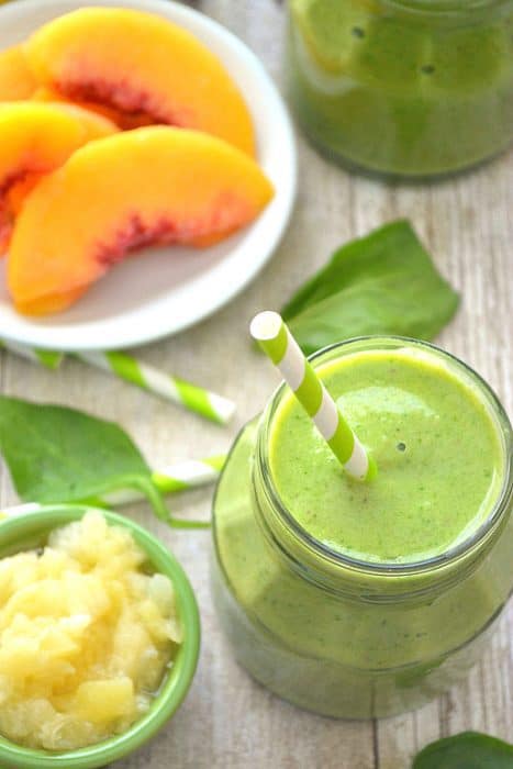 This Pineapple Peach Mango Green Smoothie is a delicious taste of the tropics! Loaded with peaches, mango, pineapple juice, bananas, and spinach....this smoothie is flavor-packed and perfect for any time of day! 