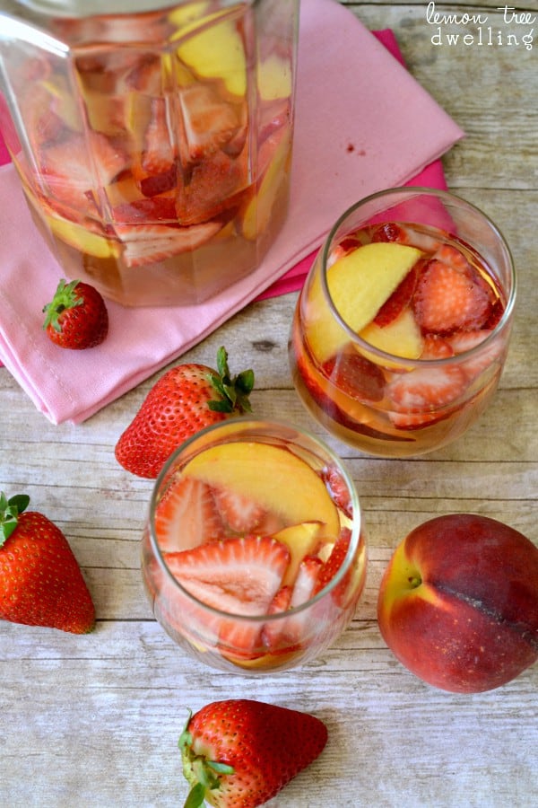  White wine sangria with fresh sliced peaches and strawberries - a beautifully delicious summer drink!
