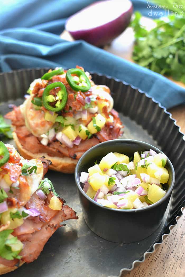 Open Face Ham & Cheese Melts topped with crispy bacon, fresh pineapple salsa, and jalapenos. 