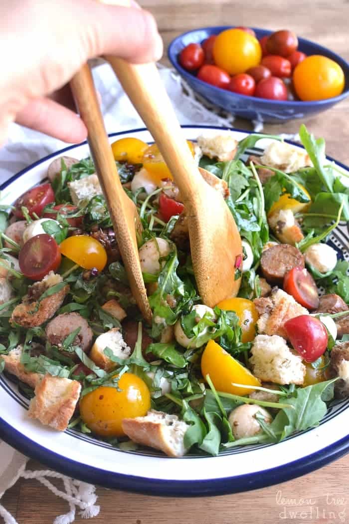 This Caprese Panzanella combines fresh arugula and crusty bread with multicolored tomatoes, fresh mozzarella, Italian sausage, and fresh basil. Drizzle it with homemade balsamic vinaigrette for a light, fresh, flavor-packed summer meal!