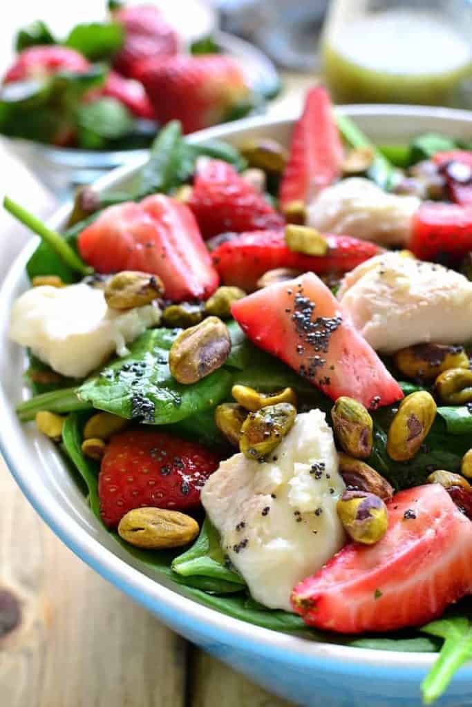 This Strawberry Spinach Salad is an AMAZING twist on a summer classic! Loaded with fresh strawberries, goat cheese, pistachios, and a delicious honey balsamic vinaigrette....this salad is sure to become your new favorite go-to for picnics, cookouts, and everyday meals!