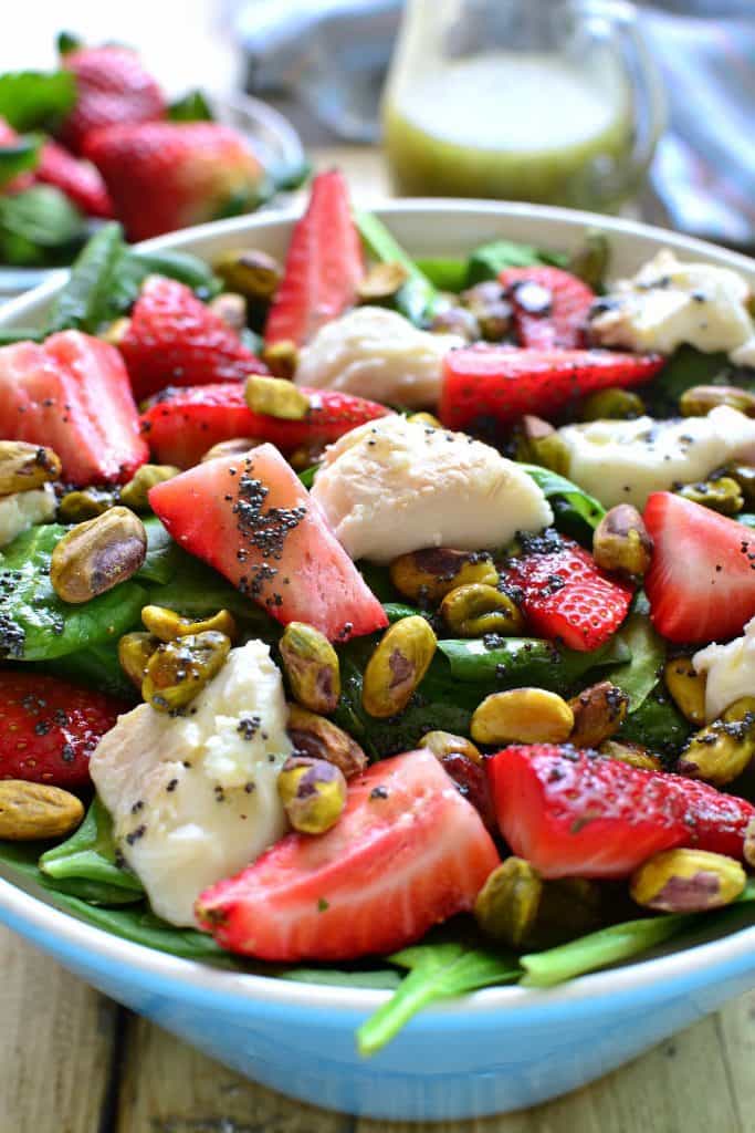 This Strawberry Spinach Salad is an AMAZING twist on a summer classic! Loaded with fresh strawberries, goat cheese, pistachios, and a delicious honey balsamic vinaigrette....this salad is sure to become your new favorite go-to for picnics, cookouts, and everyday meals!