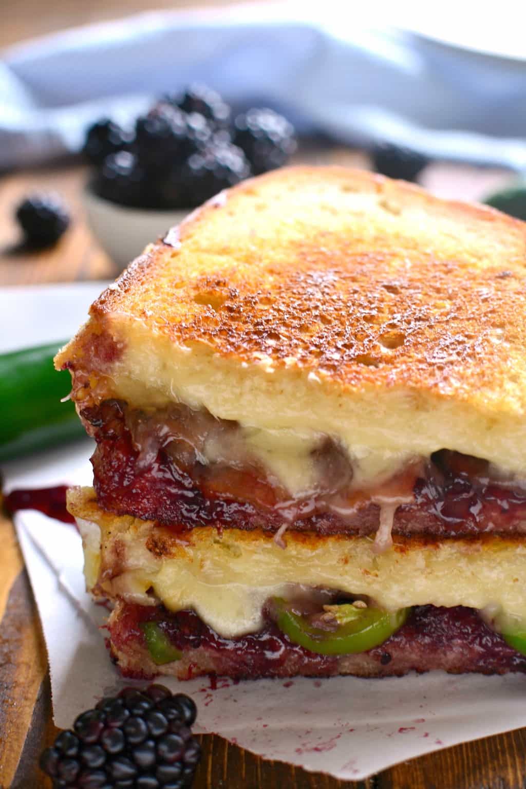 grilled cheese sandwich on white bread made with swiss cheese, blackberry jam, jalapenos and bacon