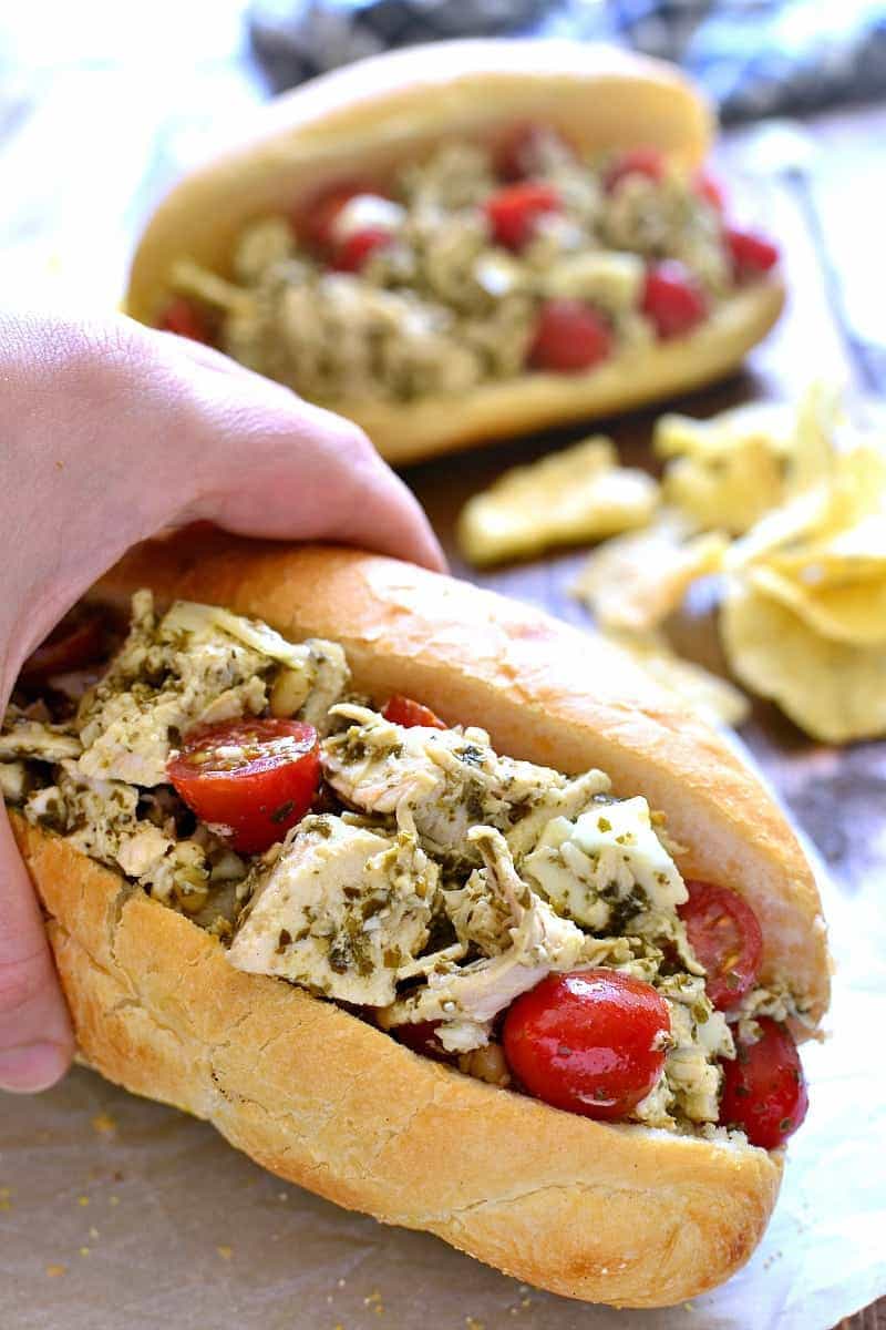 a hand holding a Pesto Chicken Salad sandwich