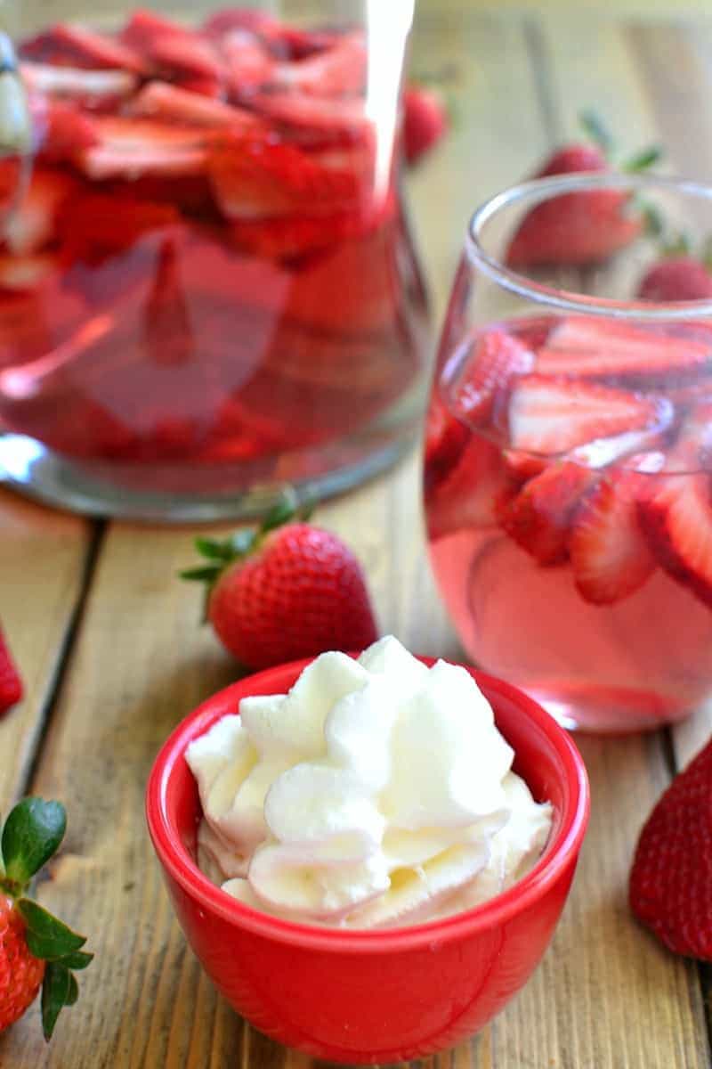 a glass and pitcher of Strawberry Shortcake Sangria