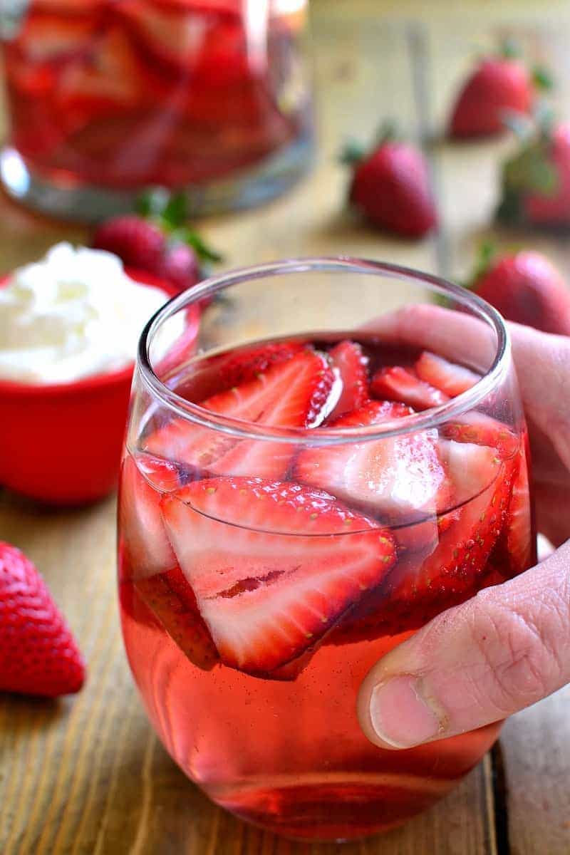 hand holding a glass of Strawberry Shortcake Moscato Sangria