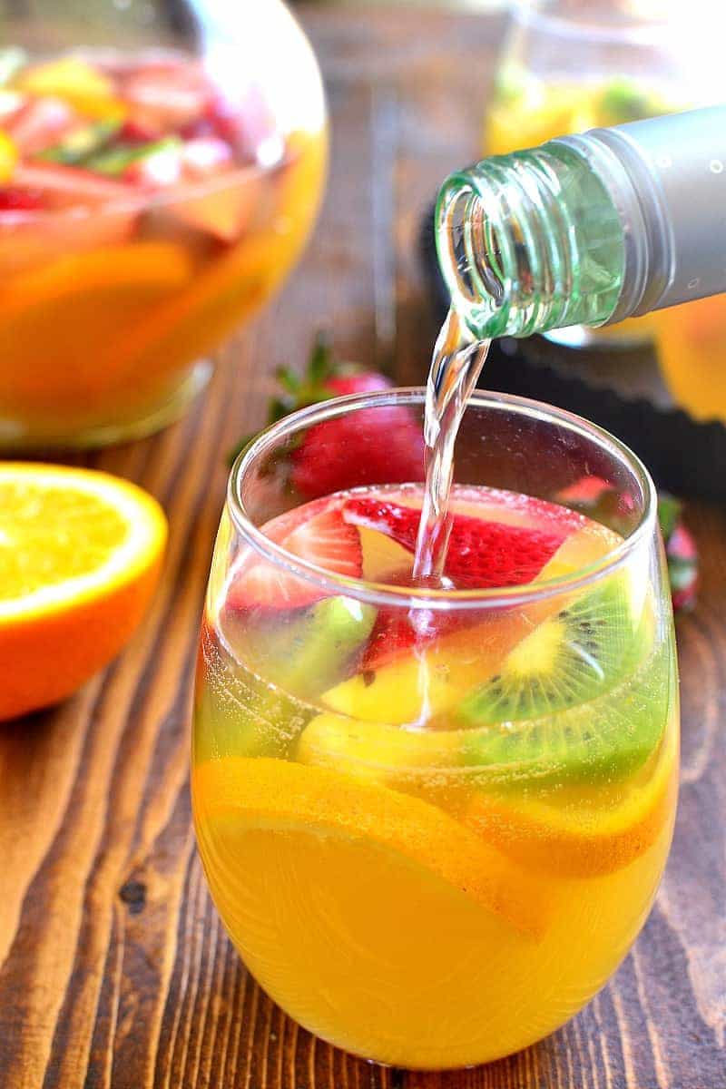 white wine being poured into a glass of sangria