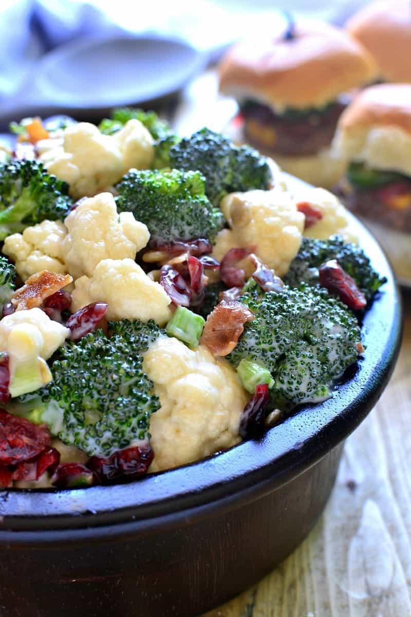 The BEST Broccoli Salad recipe - loaded with fresh broccoli, cauliflower, green onions, bacon, sunflower seeds, dried cranberries, and a lightened up honey mustard dressing. This salad is perfect for summer cookouts and picnics - a definite crowd pleaser!