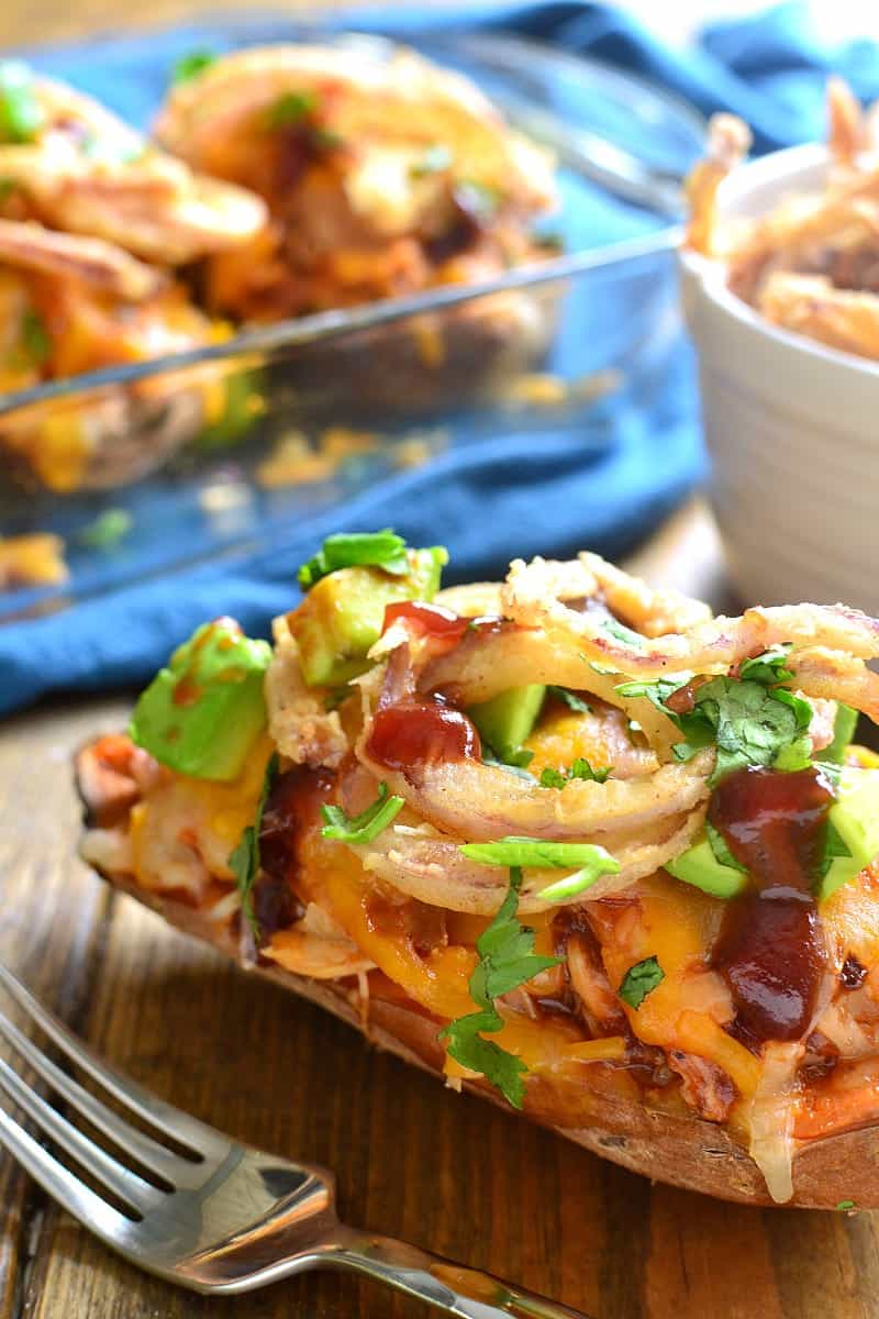 These BBQ Chicken Baked Sweet Potatoes are the best combination of savory & sweet! Loaded with shredded bbq chicken, melted cheese, avocado, cilantro, and crispy onion strings, they're a delicious break from the dinnertime rut!