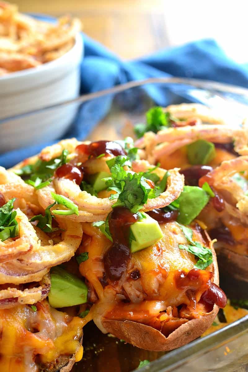 These BBQ Chicken Baked Sweet Potatoes are the best combination of savory & sweet! Loaded with shredded bbq chicken, melted cheese, avocado, cilantro, and crispy onion strings, they're a delicious break from the dinnertime rut!