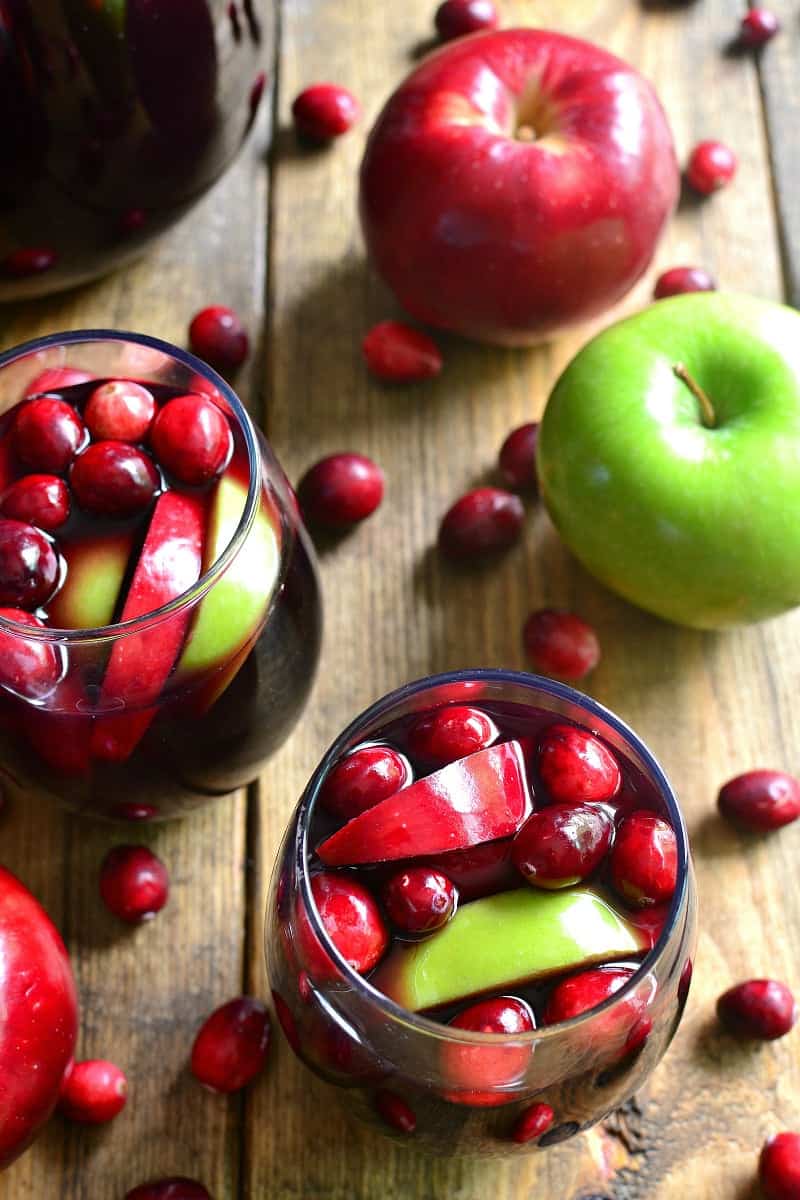 Glasses of red wine sangria with fresh cranberries and apples