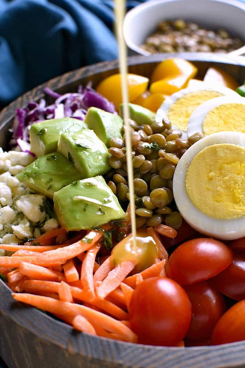 Lentil Protein Salad being dressed with a light vinaigrette dressing