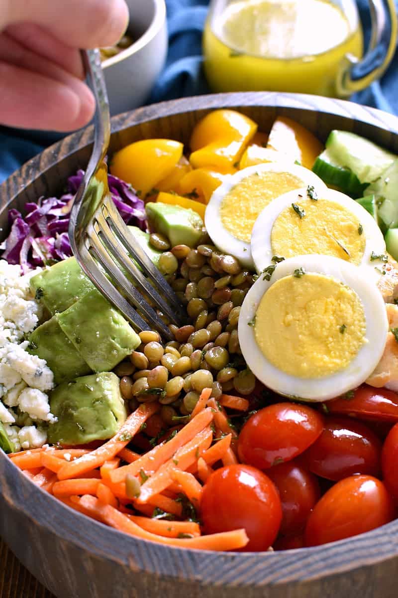 wooden bowl of protein packed salad with a fork in it