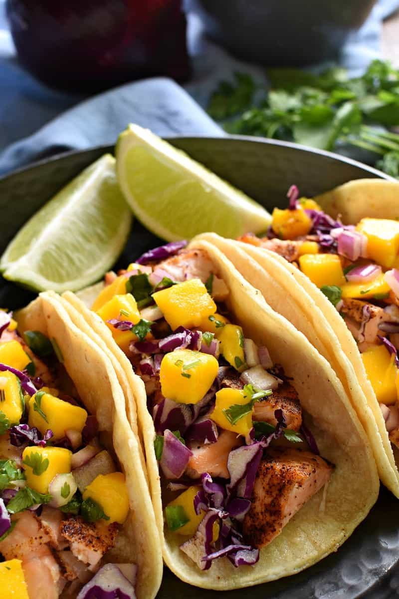 platter of Fish Tacos made with salmon. Tacos are topped with mango salsa