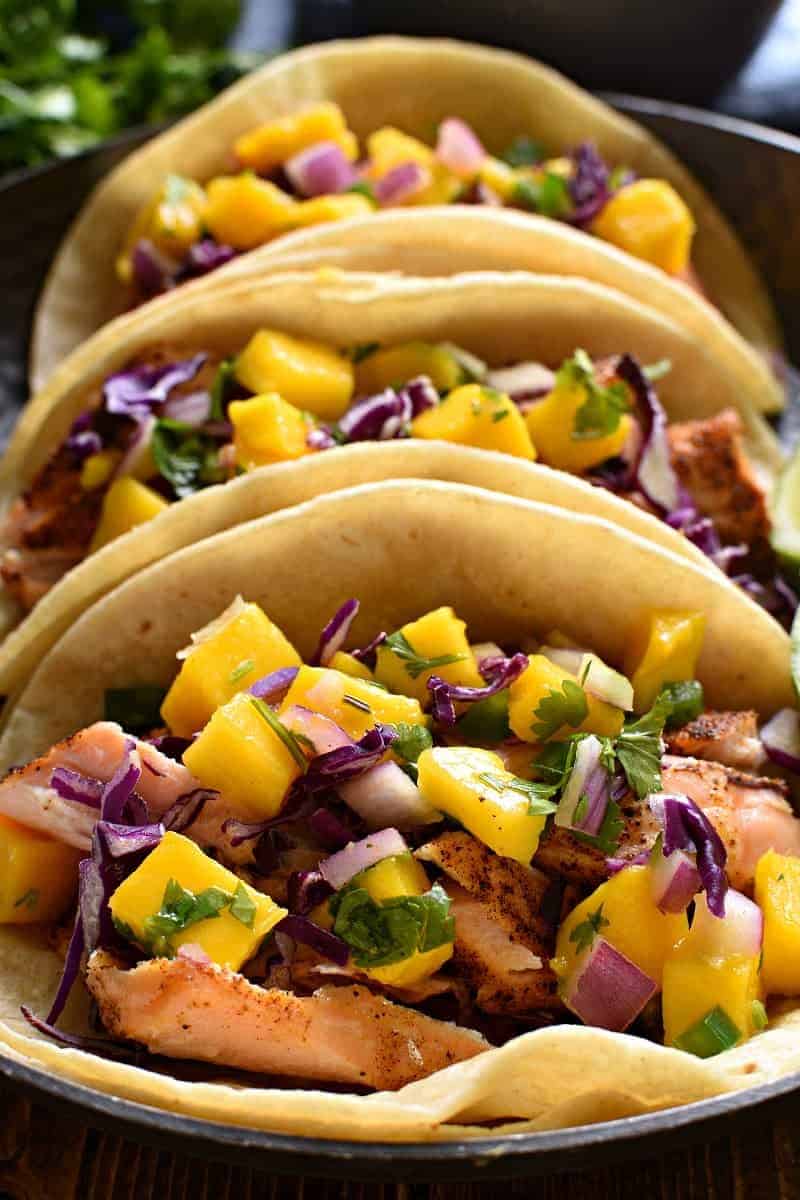 closeup image of the inside of salmon tacos with mango salsa