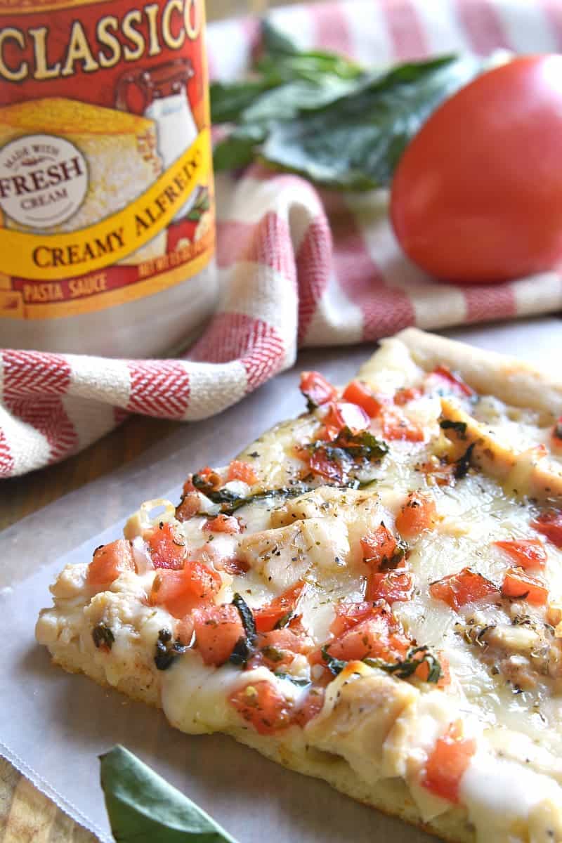 This Bruschetta Chicken Alfredo Pizza is a little taste of Italy, right in your own kitchen! Packed with delicious flavor and ready in under 30 minutes, this pizza is perfect for family night, date night, or a fun night with friends!