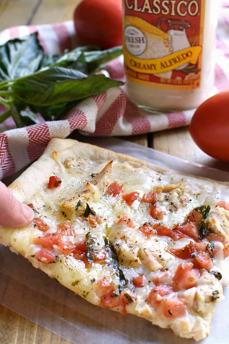 This Bruschetta Chicken Alfredo Pizza is a little taste of Italy, right in your own kitchen! Packed with delicious flavor and ready in under 30 minutes, this pizza is perfect for family night, date night, or a fun night with friends!