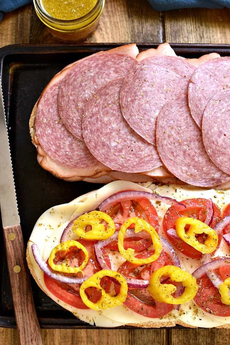 This Baked Italian Party Sub is perfect for feeding a crowd! Loaded with the delicious flavors of salami, turkey, ham, provolone, tomatoes, peppers, red onions, and homemade Italian vinaigrette, this sandwich is party-ready whenever you are....and guaranteed to make all your guests very happy!