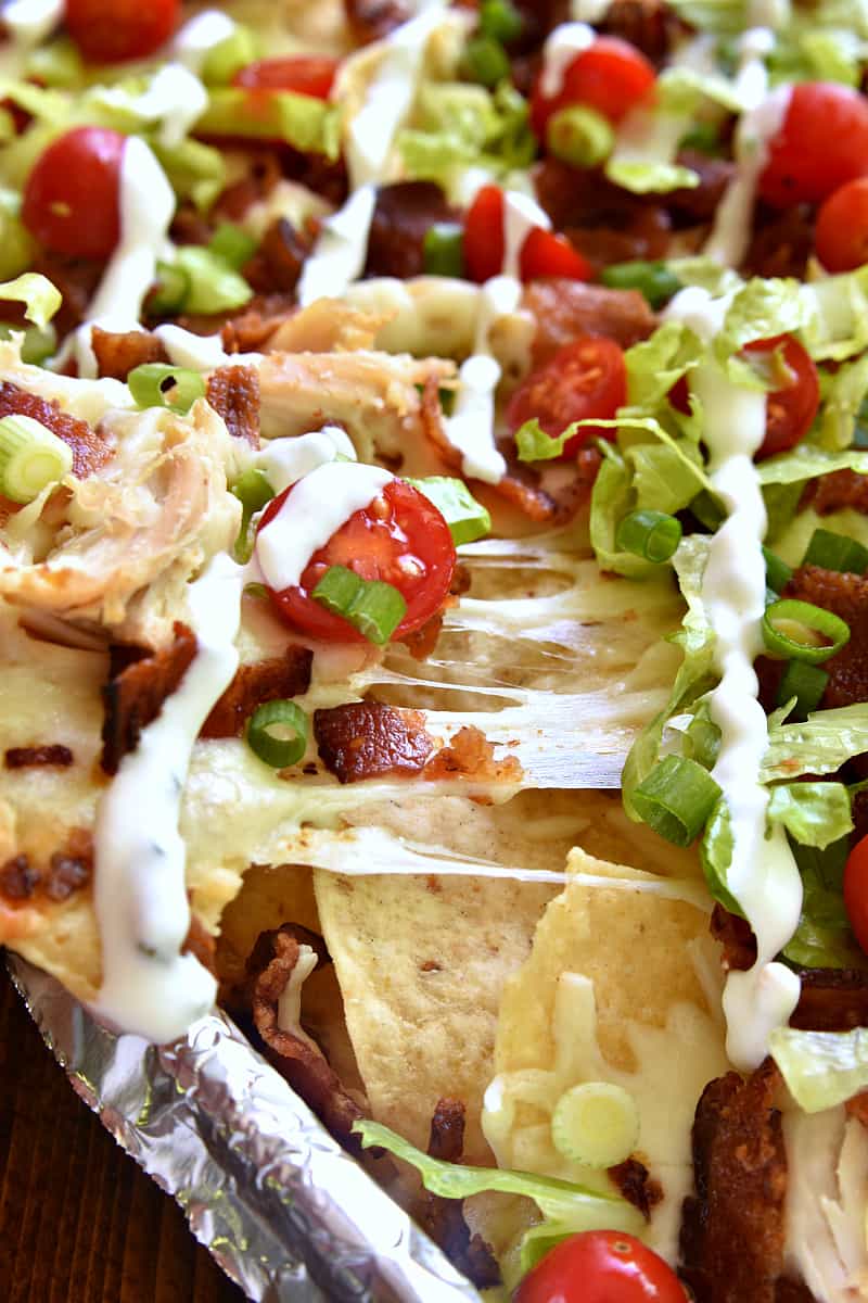 These BLT Chicken Nachos are the ultimate combo! Bacon, lettuce, and tomato come together with Monterey Jack cheese and crunchy tortilla chips in a delicious sheet pan recipe that's sure to please a crowd!
