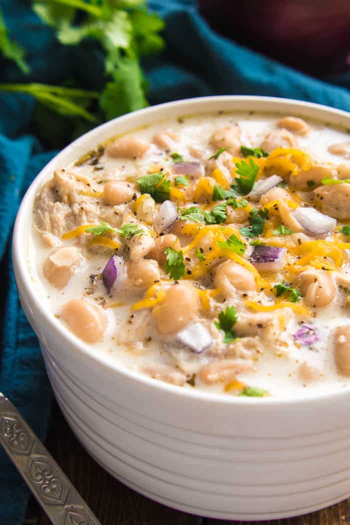 The BEST White Chicken Chili! If you love chili, you'll love this creamy, delicious twist! This recipe comes together quickly and is always a favorite - perfect for game days, weeknight dinners, and family gatherings. Make it with rotisserie chicken for an extra easy dinner, and top it with all your favorites for a delicious dish everyone will love! Whether you're a traditional chili fan or prefer white bean chili, you'll love the amazing flavor in this Creamy White Chicken Chili recipe....sure to become a new favorite!