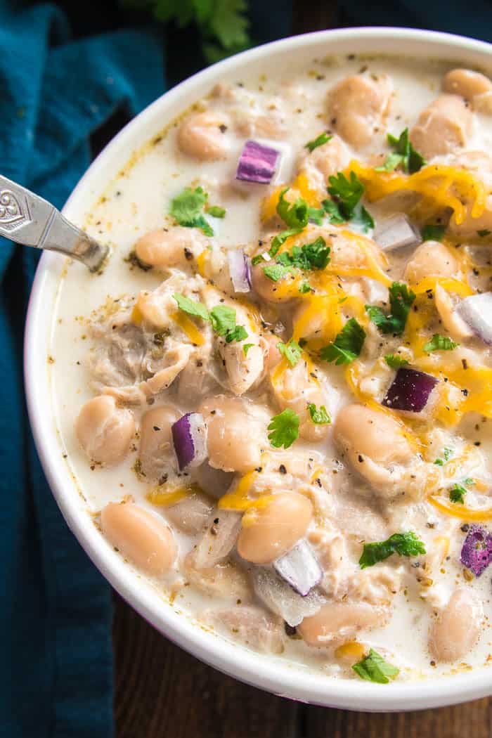 The BEST White Chicken Chili! If you love chili, you'll love this creamy, delicious twist! This recipe comes together quickly and is always a favorite - perfect for game days, weeknight dinners, and family gatherings. Make it with rotisserie chicken for an extra easy dinner, and top it with all your favorites for a delicious dish everyone will love! Whether you're a traditional chili fan or prefer white bean chili, you'll love the amazing flavor in this Creamy White Chicken Chili recipe....sure to become a new favorite!