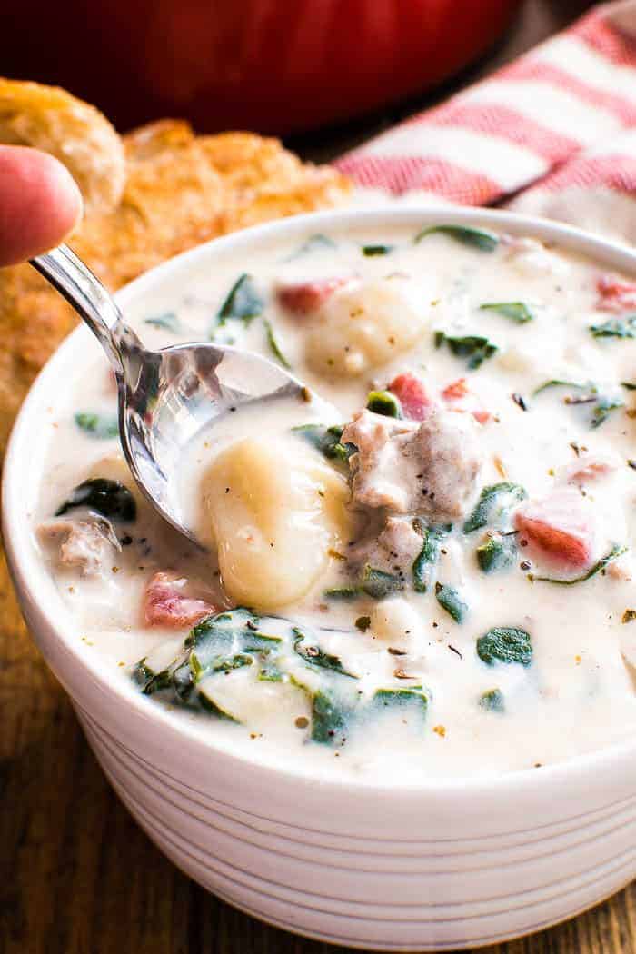 Creamy Sausage Gnocchi Soup combines the delicious flavors of Italian Sausage, tomatoes, spinach, and gnocchi in a deliciously creamy, flavor-packed soup. If you like Olive Garden's Zuppa Toscana, you'll love this yummy homemade version even more! Made with gnocchi and spinach in place of potatoes and kale, this soup makes a hearty, satisfying meal the whole family will love. And since it's easy to make and ready in under 30 minutes, it's perfect for busy weeknights and reheats well for weekday lunches. Once you taste the amazing flavors in this rich, creamy soup, you'll see why it's one of our family's favorites!