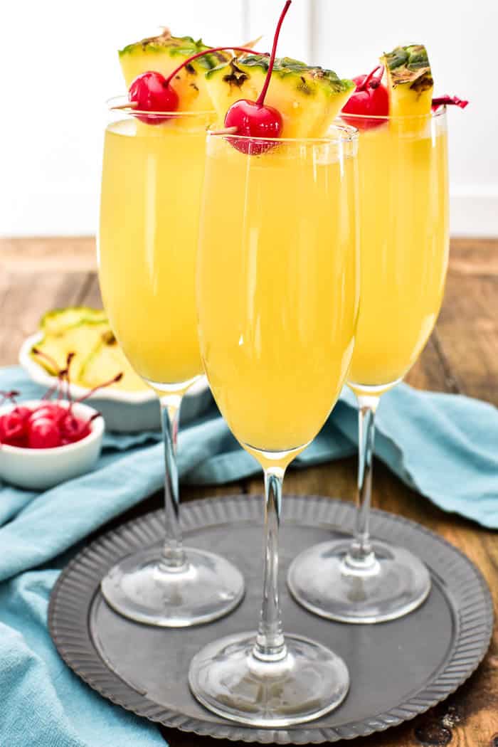 Pineapple Upside Down Mimosas are one of our favorite brunch time beverages! They combine the classic mimosa you know and love with the delicious taste of pineapple upside down cake. Made with just 3 simple ingredients, these drinks are easy to prepare and perfect for any occasion. Make your next brunch extra special with these extra special (extra yummy!) mimosas!