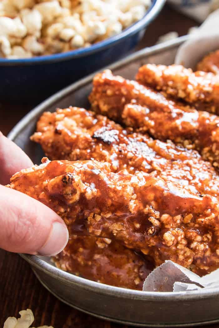 Honey BBQ Chicken Tenders are the perfect option for easy weeknight dinners! Tender, juicy chicken dipped in barbecue sauce, coated in crunchy kettle corn, and finished off with a sweet honey barbecue glaze. These chicken tenders are oven-baked and make a delicious family meal!