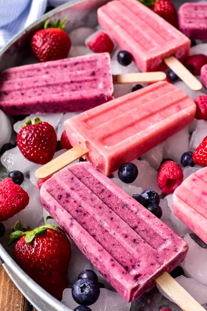 Fruit Smoothie Popsicles are one of our favorite summer treats! They combine all the flavors of a fruit smoothie with all the fun a popsicle. Made with just three simple ingredients, these fruit smoothie popsicles come together in minutes and make a delicious breakfast, snack, or after dinner treat. They can be made with any combination of fruit, which means theres a flavor combination for everyone! Whether you're a smoothie lover or looking to eat healthier this summer, these Fruit Smoothie Popsicles are destined to become a new summer (or year round) favorite!