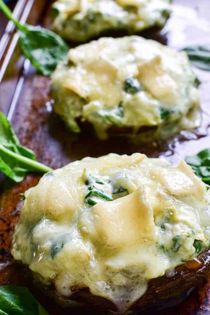 These Spinach Artichoke Stuffed Portobellos make a delicious appetizer, side dish, or meatless main dish. Loaded with a creamy blend of fresh spinach, artichoke hearts, sour cream, cheeses, and seasonings, these portobello mushroom caps are topped with brie cheese and baked to gooey perfection. @reesespecialty #sponsored