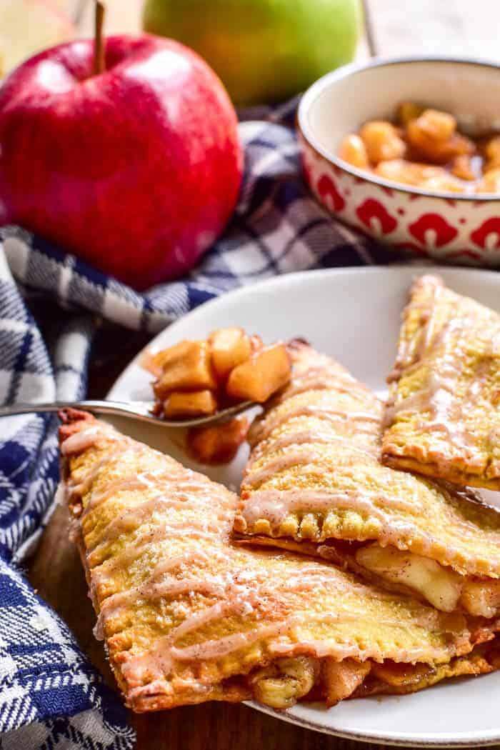 Apple Pie meets Baked Brie in these delicious Apple Brie Turnovers. Stuffed with homemade apple pie filling and creamy brie cheese, they're the perfect combination of savory and sweet. These turnovers make a delicious breakfast, snack, or dessert, and they're fun to eat & easy to make. If you love apple turnovers you'll love this unique, savory twist!