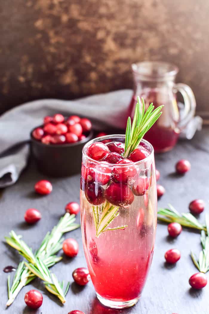 These Cranberry Mimosas are the ultimate holiday cocktail! Made with simple ingredients and garnished with fresh cranberries and a sprig of rosemary, these mimosas are sure to become your new favorite champagne cocktail. They're perfect for brunch, holiday parties, or even Christmas day. Best of all, they're made with just 3 ingredients and are easy to make by the glass or pitcherful for simple, stress-free holiday entertaining!