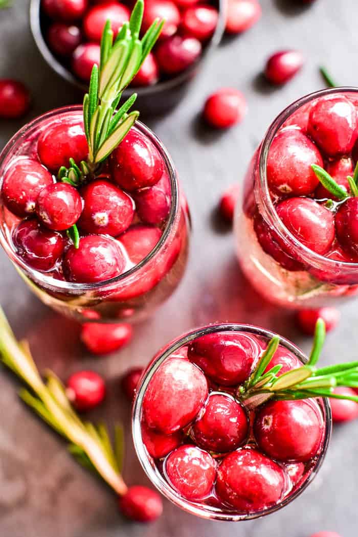 These Cranberry Mimosas are the ultimate holiday cocktail! Made with simple ingredients and garnished with fresh cranberries and a sprig of rosemary, these mimosas are sure to become your new favorite champagne cocktail. They're perfect for brunch, holiday parties, or even Christmas day. Best of all, they're made with just 3 ingredients and are easy to make by the glass or pitcherful for simple, stress-free holiday entertaining!