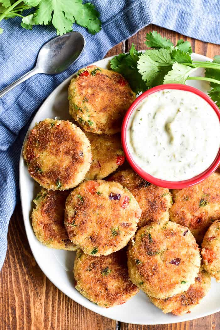 Mini Crab Cakes make the perfect holiday appetizer! All the flavors of the delicious crab cakes you love in a delicious bite-sized appetizer that's party-friendly and sure to be a favorite. These crab cakes are loaded with lump crab meat, red pepper, red onion, and cilantro. They're packed with flavor and delicious all on their own or with homemade garlic aioli.