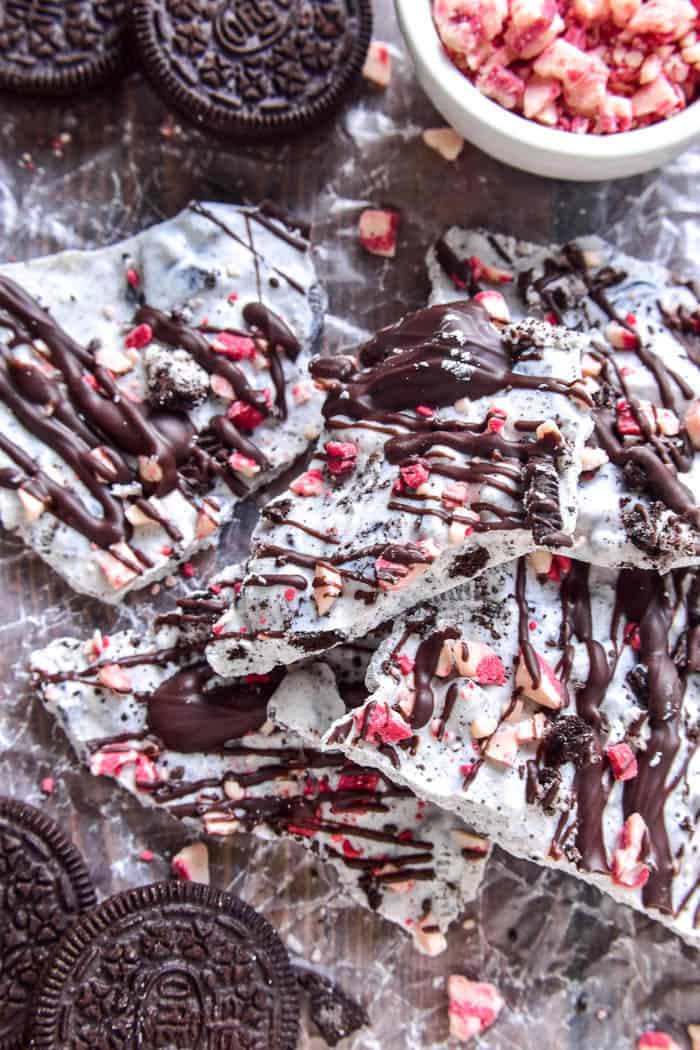 Oreo Peppermint Bark is one of our holiday favorites! Creamy white chocolate loaded with crushed Oreos and peppermint pieces, then topped with crunchy Oreos and a drizzle of milk chocolate. This bark is easy to make and SO addictive....and it makes the best holiday gift!