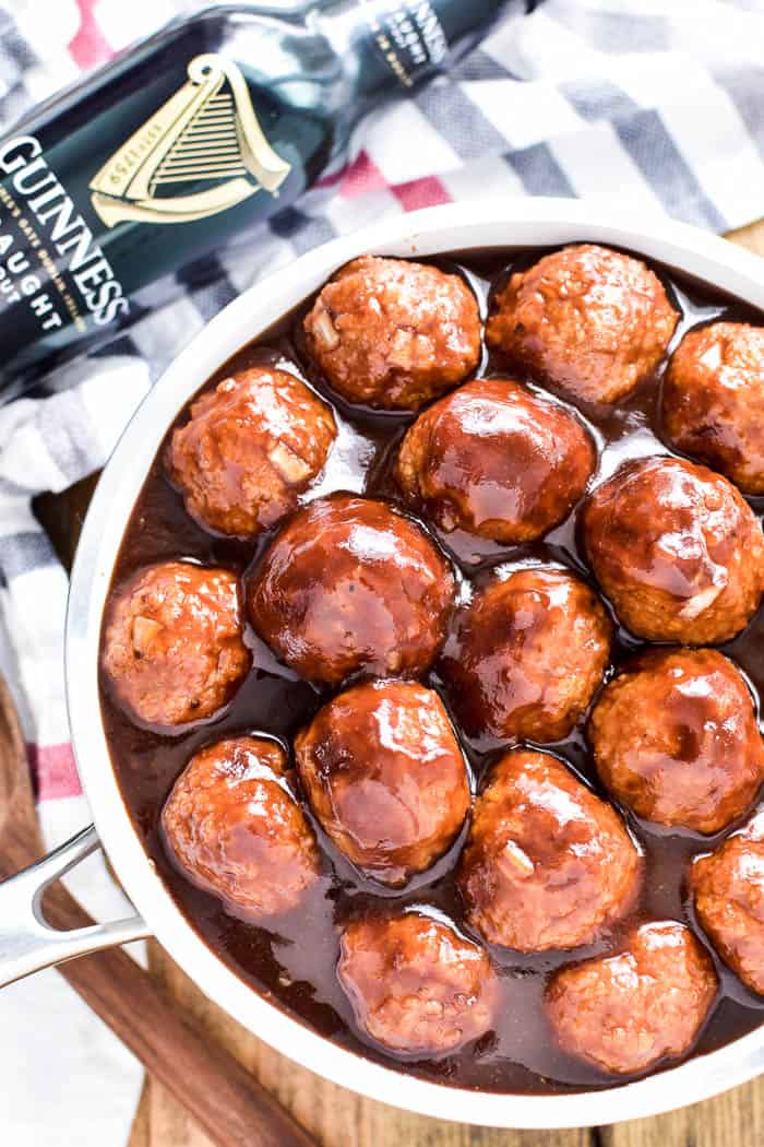 Overhead image of meatballs in saucepan with Guinness bottle