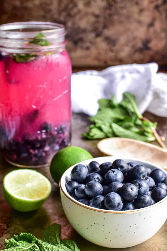 Fresh blueberries in a bowl with fresh mint and limes