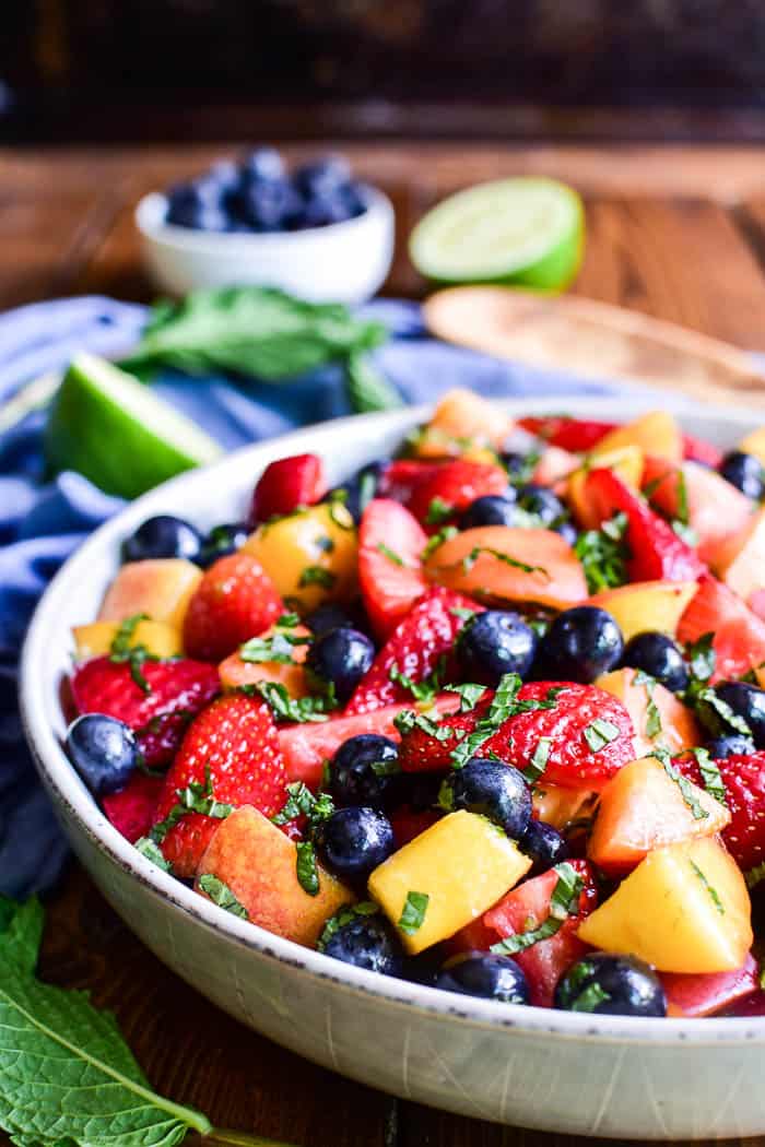 Mojito Fruit Salad in a bowl with blueberries, limes, and fresh mint