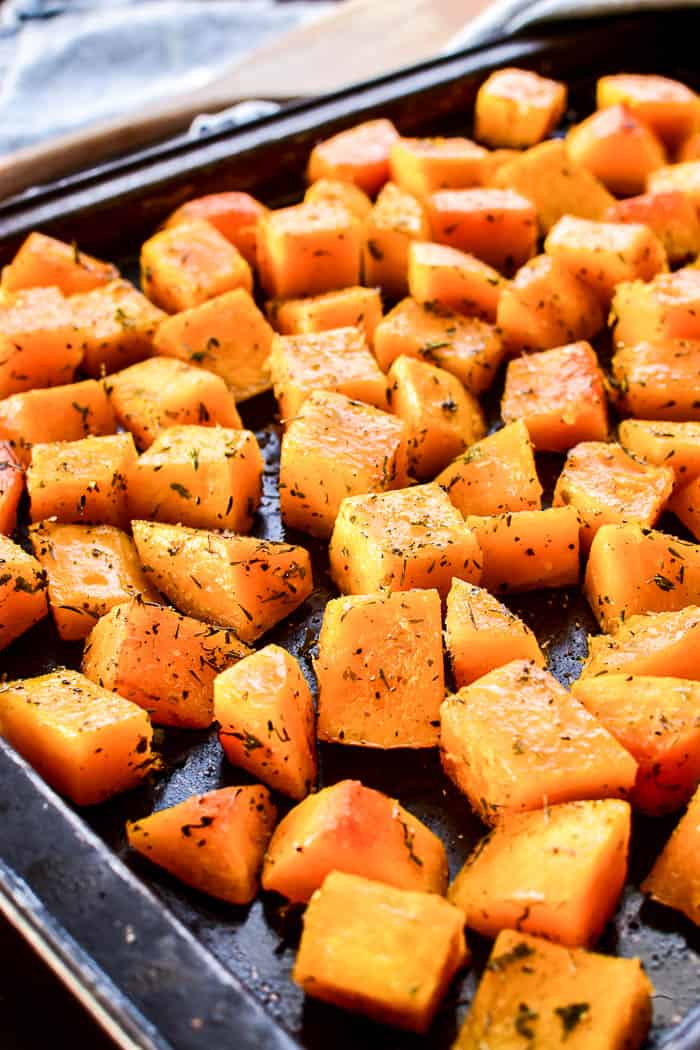 Seasoned butternut squash on roasting pan