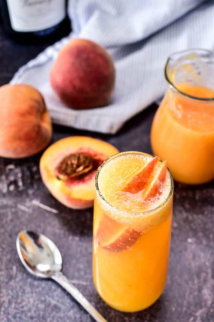 Bellini with fresh peach slices and ingredients