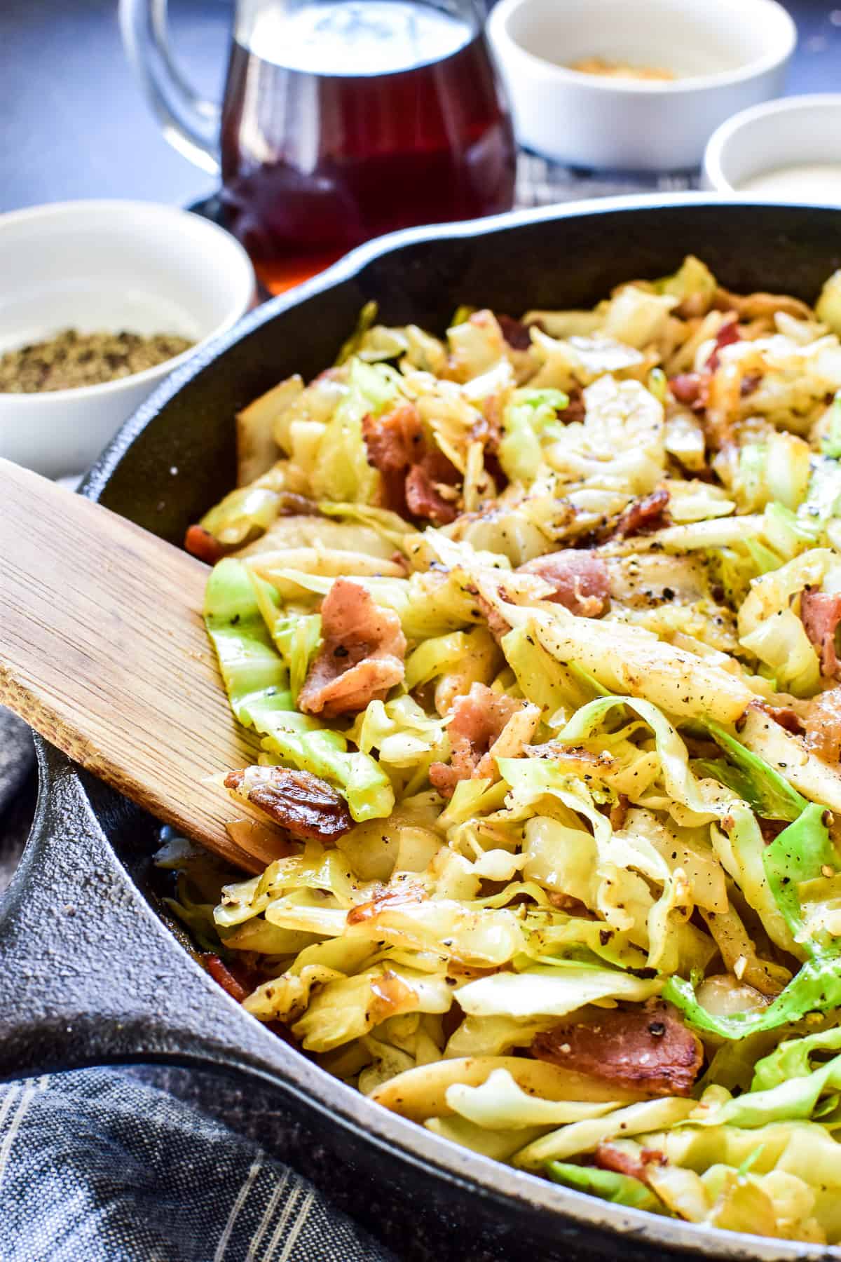 Side view of fried cabbage & bacon in cast iron skillet 