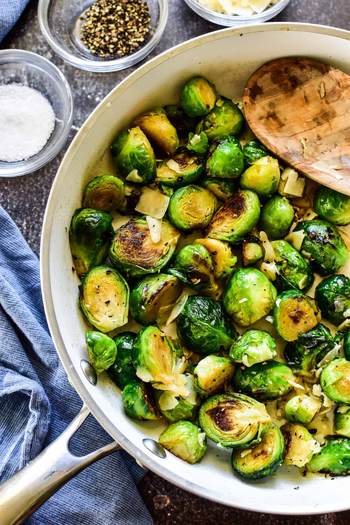 Overhead shot of Sauteed Brussel Sprouts in skillet with wooden spoon