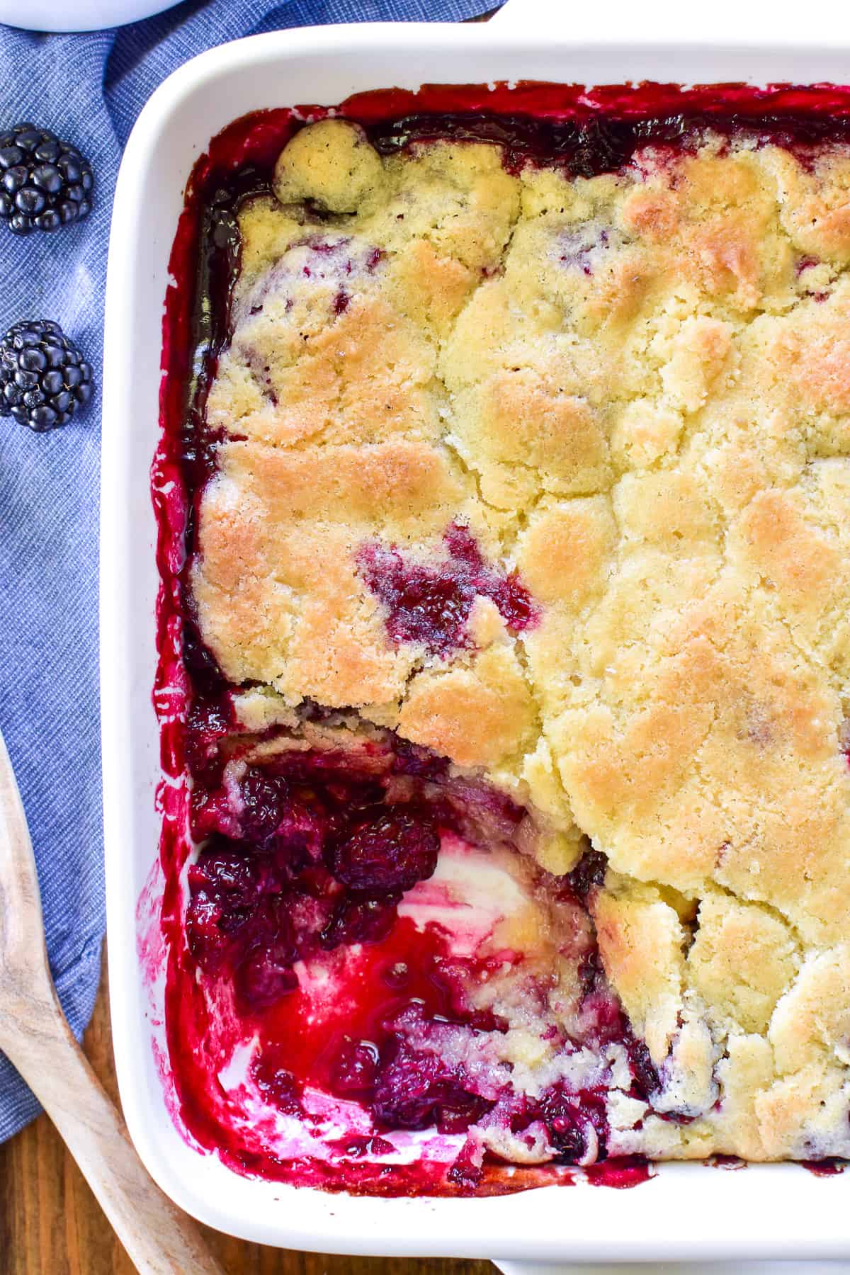 Overhead shot of Blackberry Cobbler in pan with spoonful missing