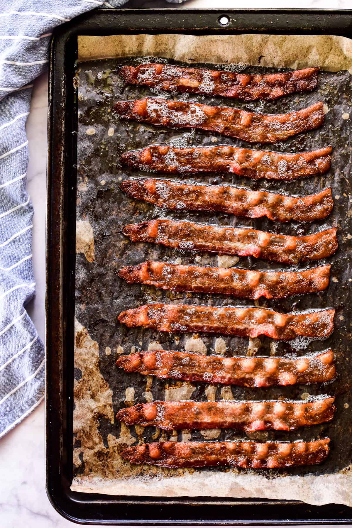 Cooked bacon on baking sheet with parchment paper